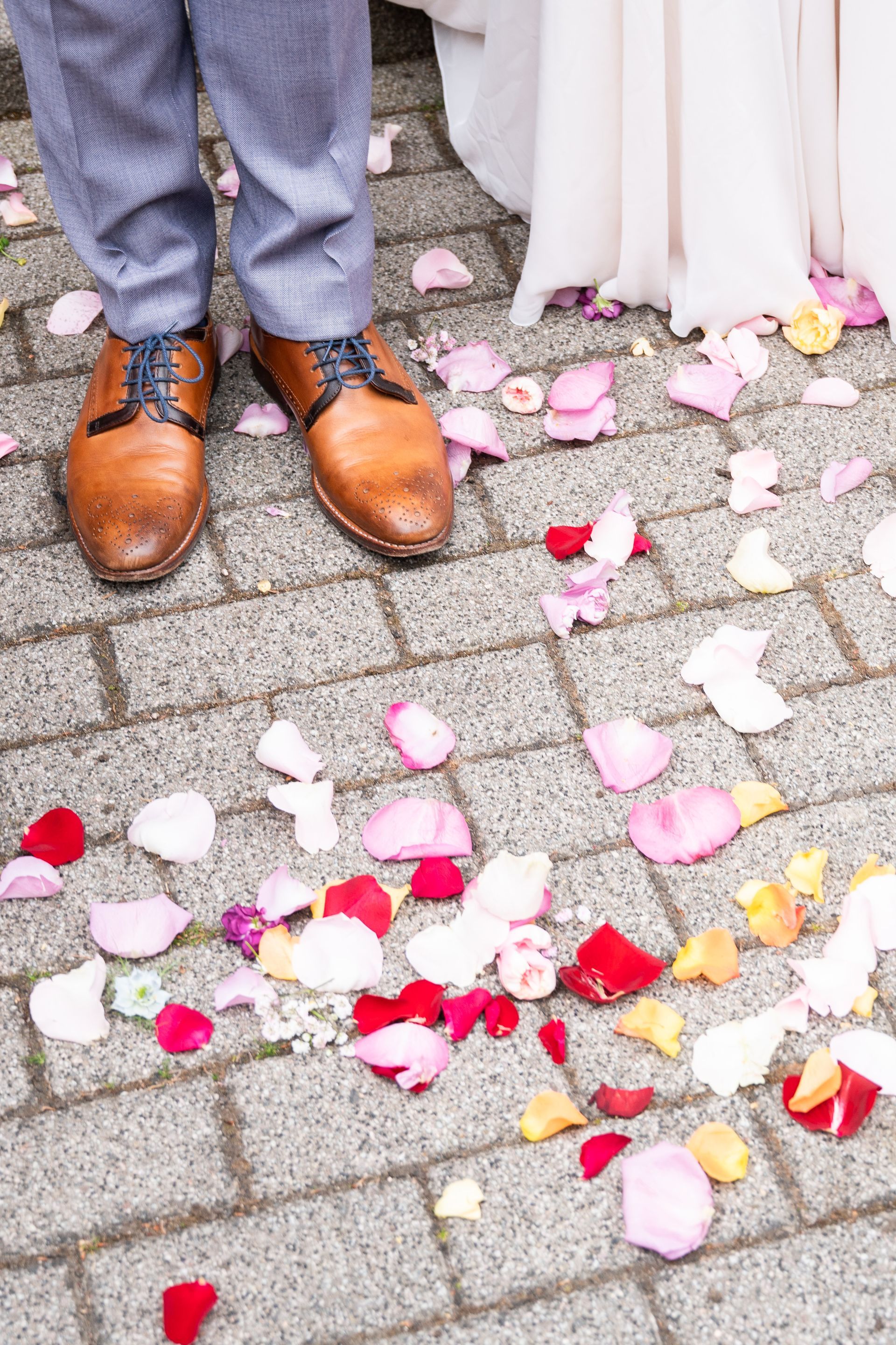 Rosenblätter liegen auf dem Boden, Schuhe vom Bräutigam