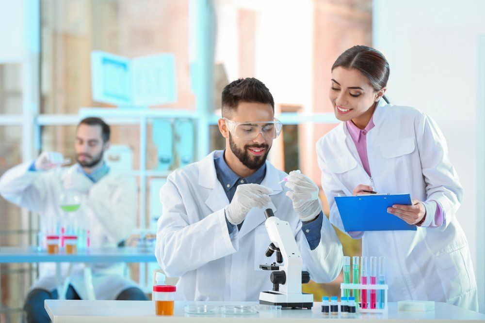 Mehrere Wissenschaftler im Labor betrachten Reagenzgläser