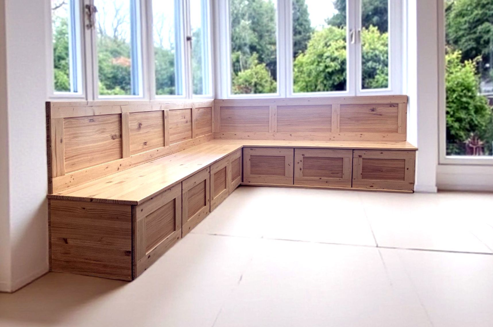 Banco esquinero de madera con cajones a lo largo de banco