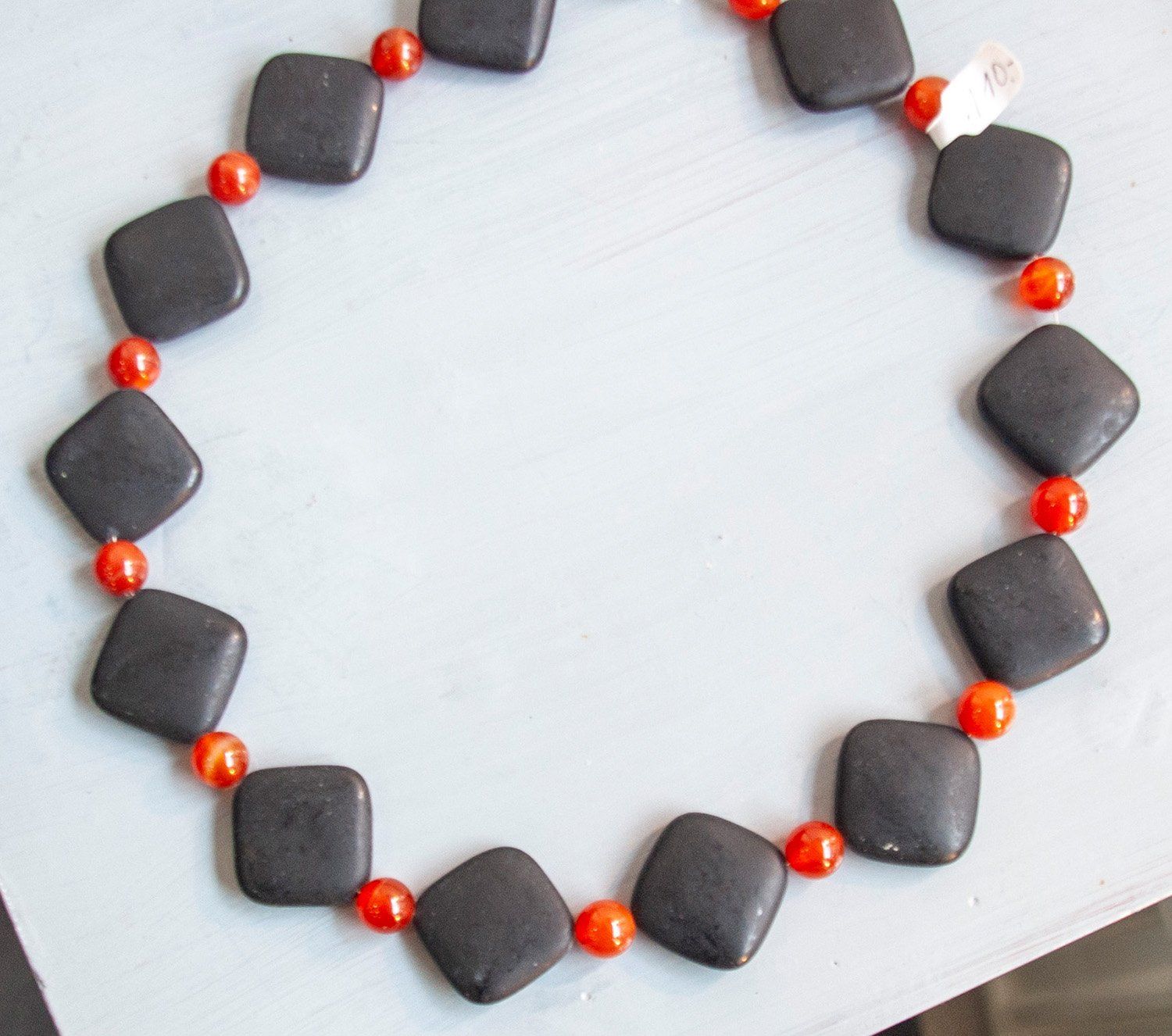 Kette bestehend aus matten Onixelementen mit Karneolkugeln