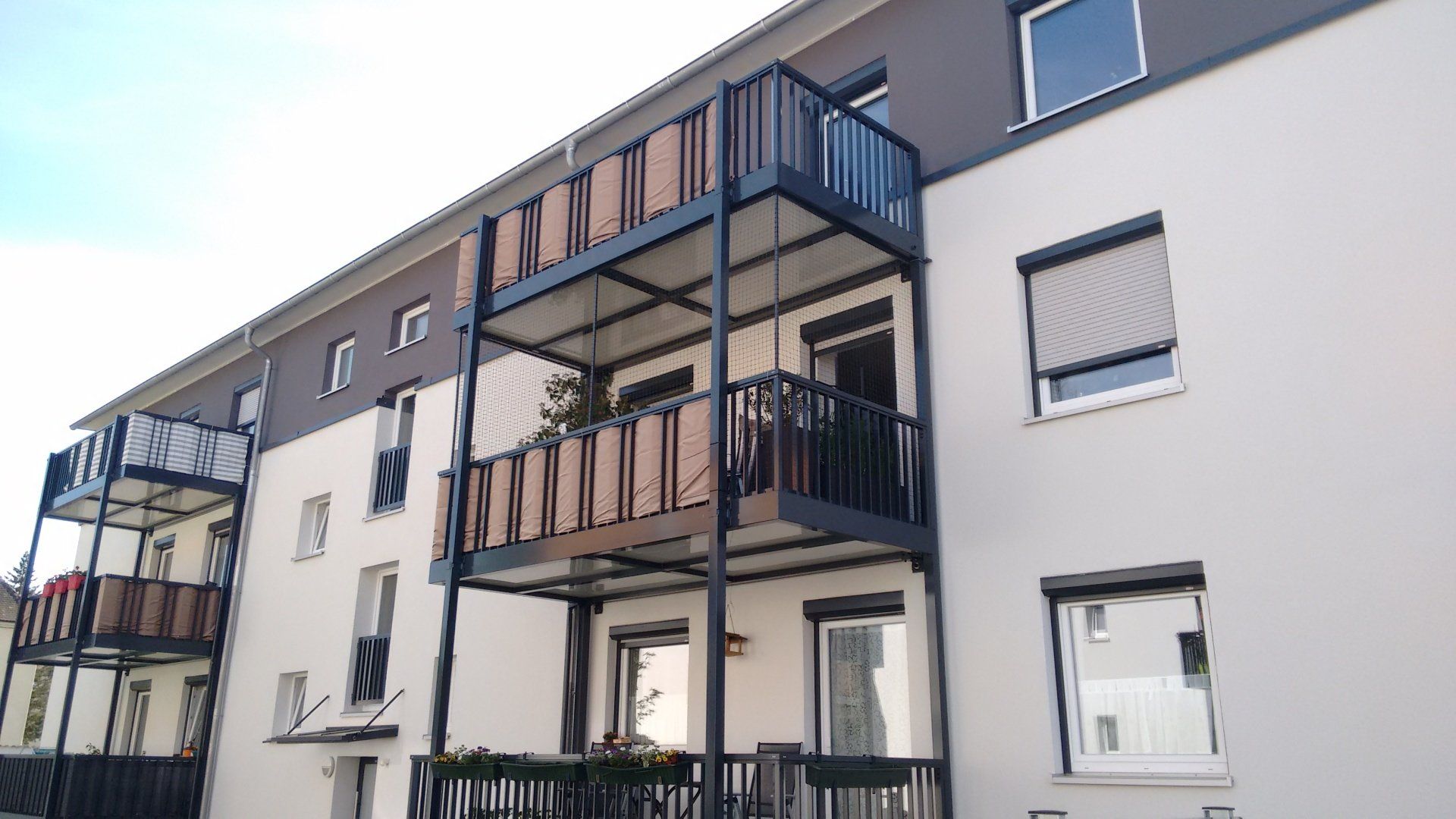 Moderner Anbaubalkon mit Pulverbeschichteten Aluprofilen und Katzennetz gesichert