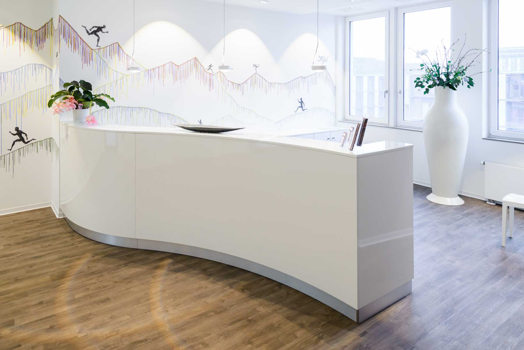 Ein geschwungener Empfangstresen von ip20 Praxiseinrichtung