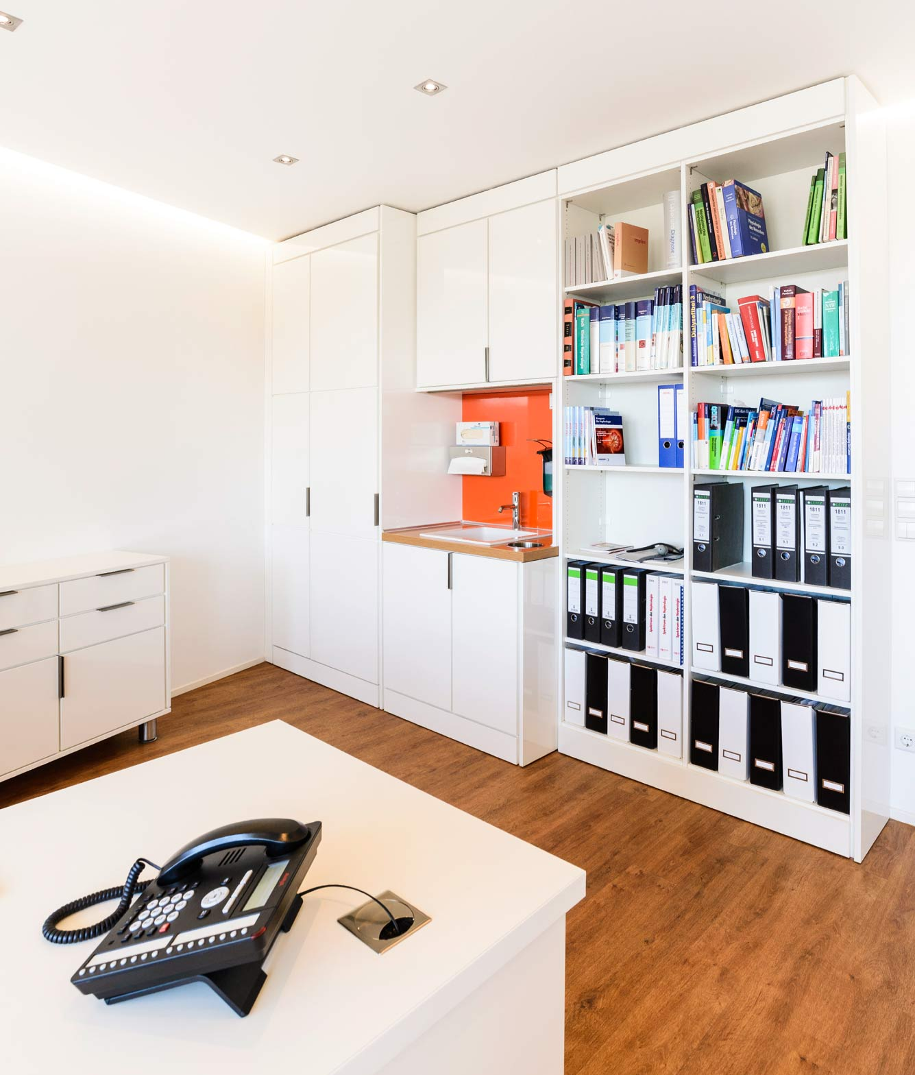 Sprechzimmer einer Arztpraxis mit in die Schrankwand integriertem Waschbecken Sprechzimmer einer Arztpraxis mit Schreibtisch und in die Schrankwand integriertem Waschbecken