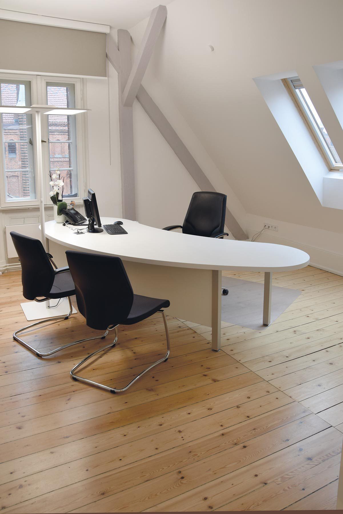 Ein Arztzimmer mit Schränken, Tischen und Sitzmöbeln von ip20 Praxiseinrichtung