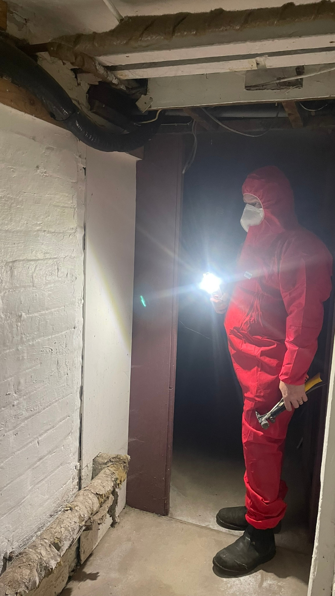 Surveyor conducting pre-demolition asbestos inspection on a residential building