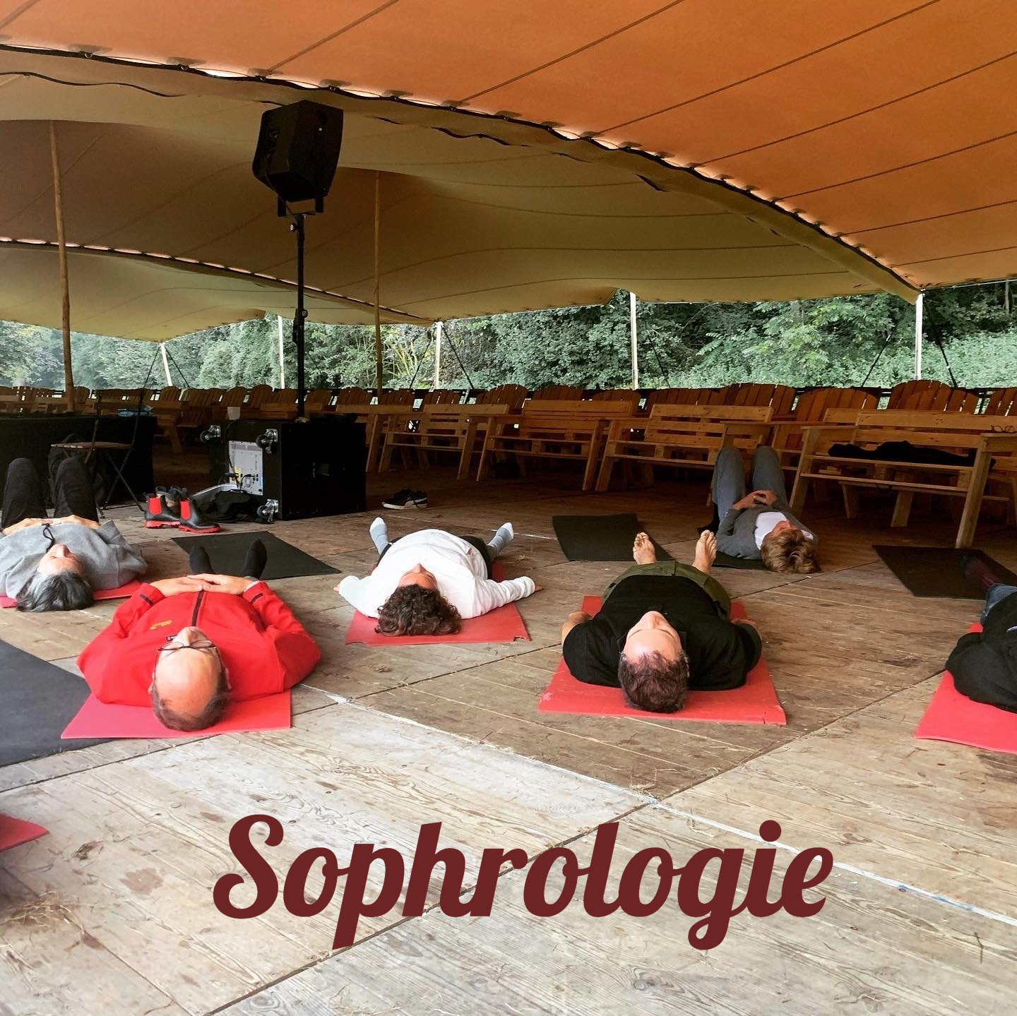 des gens allongés sur des tapis en séance de sophrologie lors d'un colloque