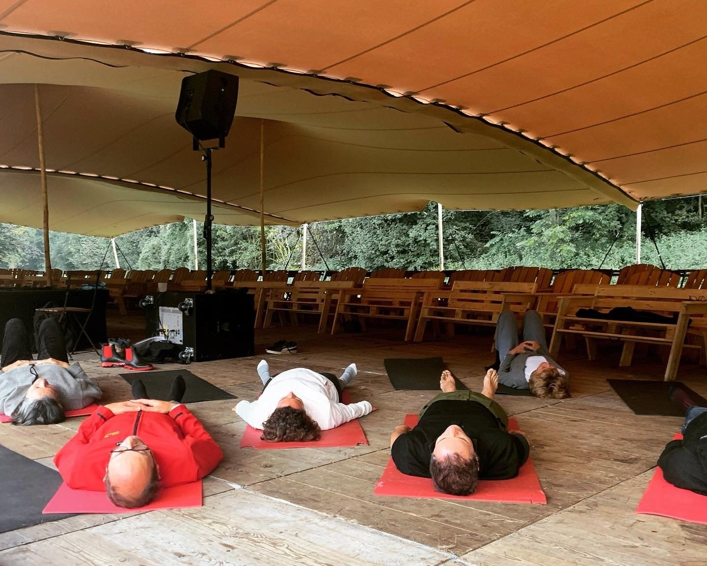 des personnes allongées sur des tapis rouges en méditation