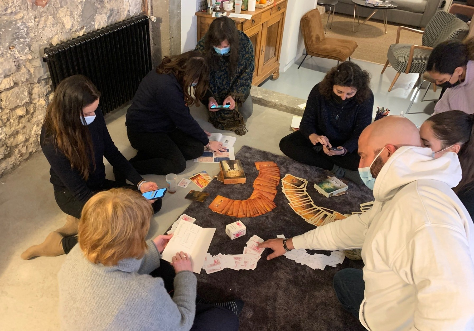 des personnes tirent des cartes d'oracles portant des masques