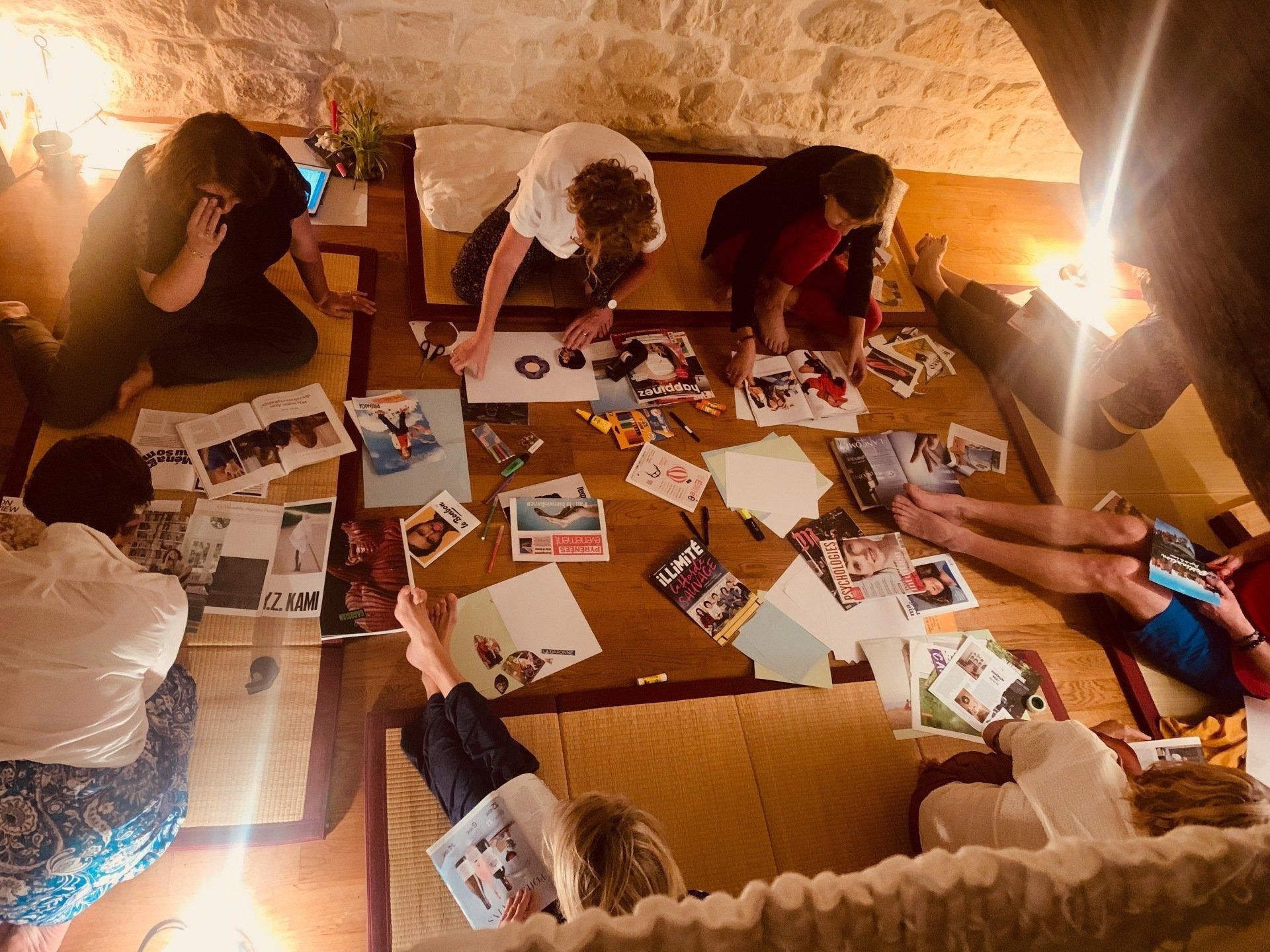 des personnes assises découpent des magazines