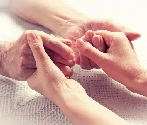 Pflegerin haltet die Hand der Oma über den Tisch Pflegerin haltet die Hand der Oma über den Tisch