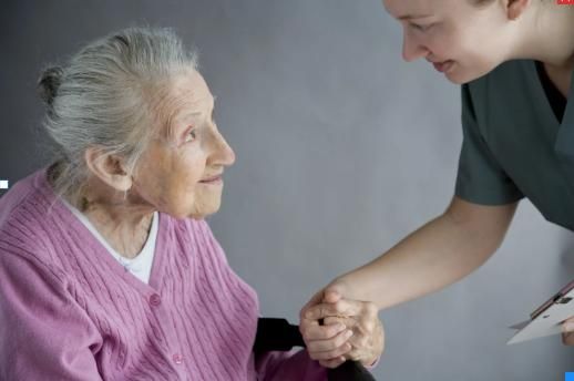 Oma sitzt und schaut freundlich auf die Pflegerin auf Oma sitzt und schaut freundlich auf die Pflegerin auf