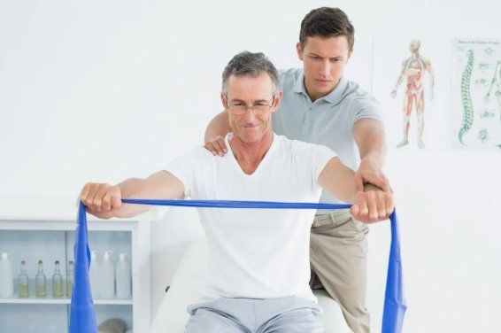 Physiotherapeut zeigt den Mann sein Trainingsprogramm Physiotherapeut zeigt den Mann sein Trainingsprogramm