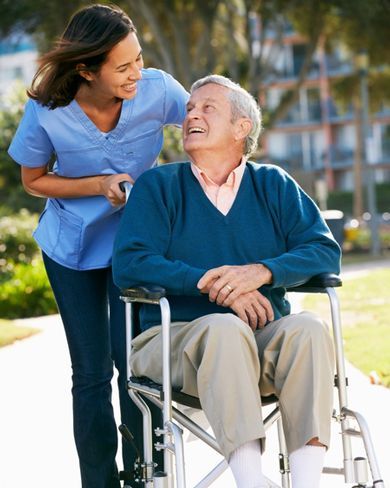 ALS Patientin liegt im Bett und DGKP prüft die Werte