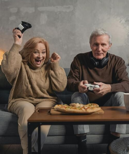 Oma und Opa spielen mit der Console und lachen dabei