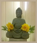 Ruhe und Achtsamkeit Buddha sitzend mit 2 gelben Rosen