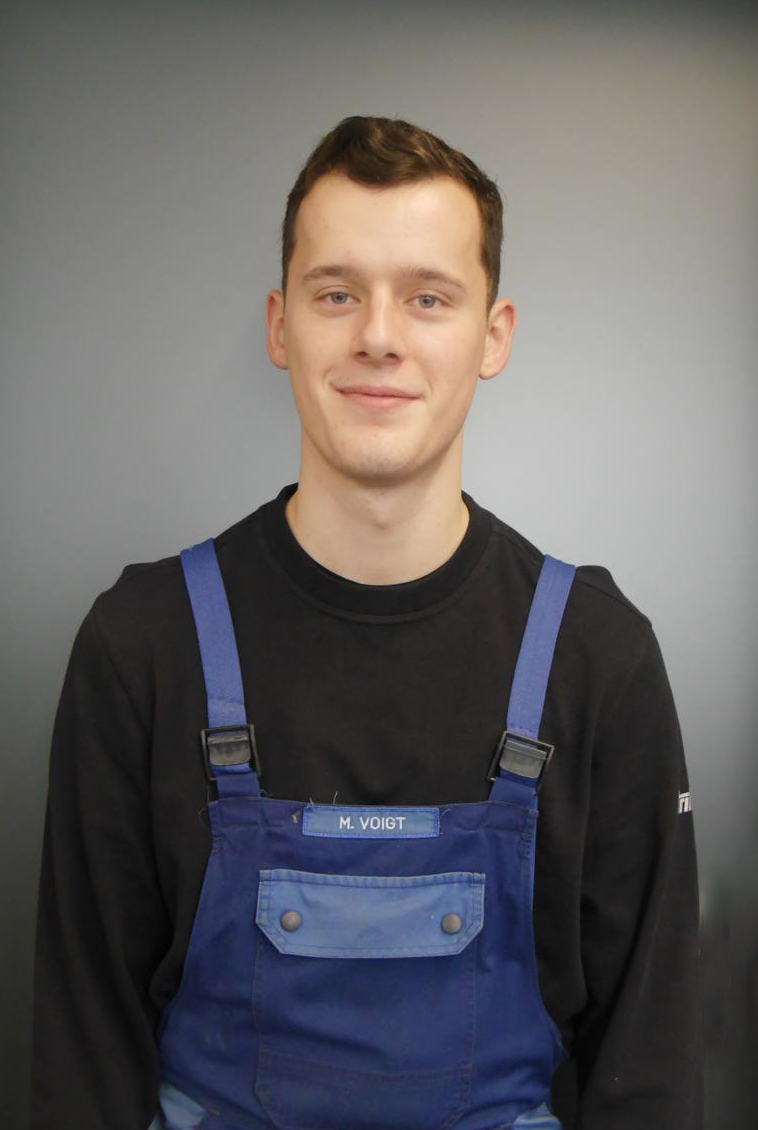 Mann mit schwarzen Tshirt und blauer Latzhose