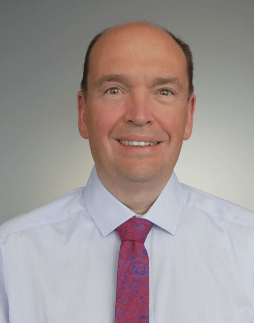 Mann mit weißen Hemd und lila Krawatte