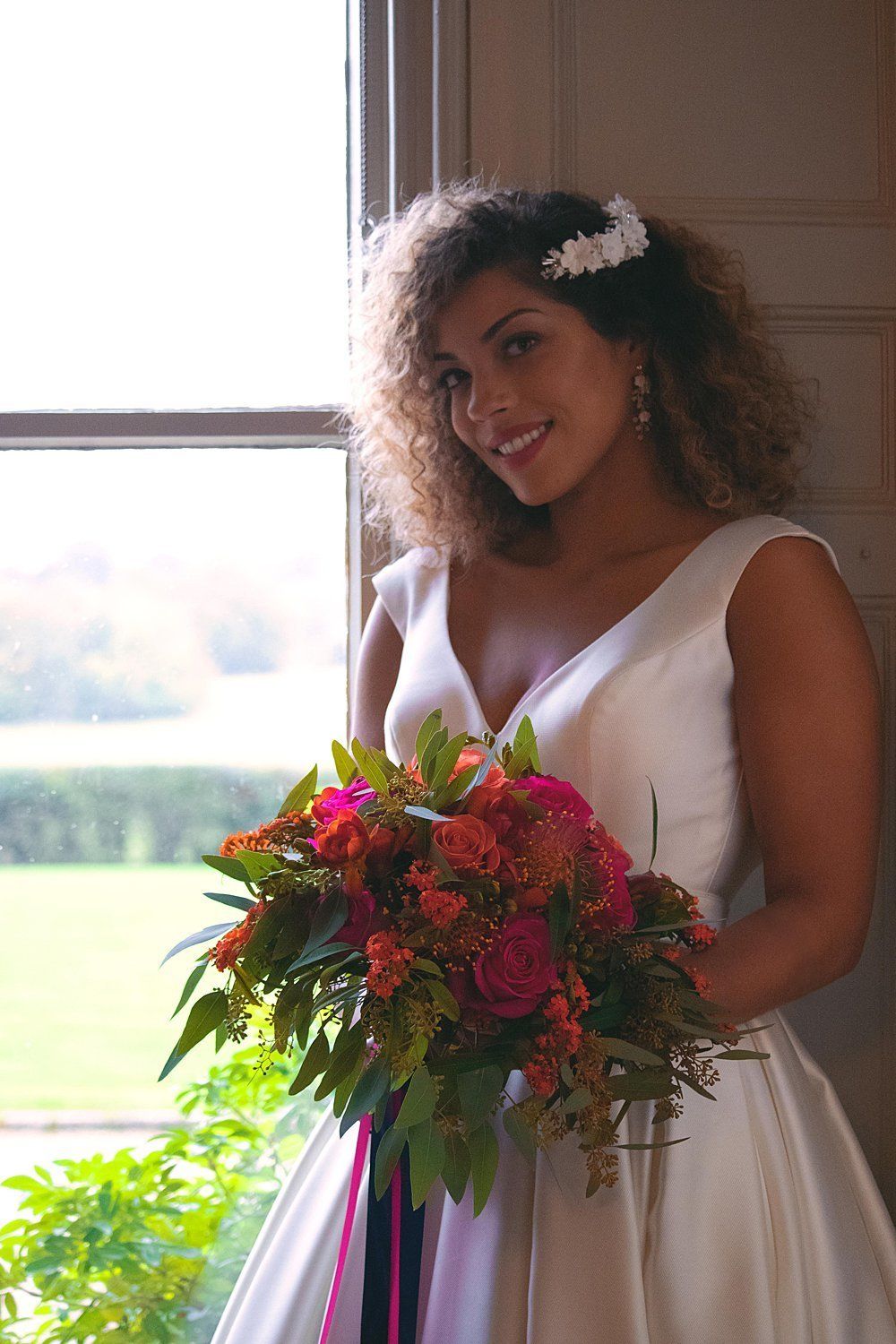 Bride inside Nurstead Court Kent holding rose bouquet