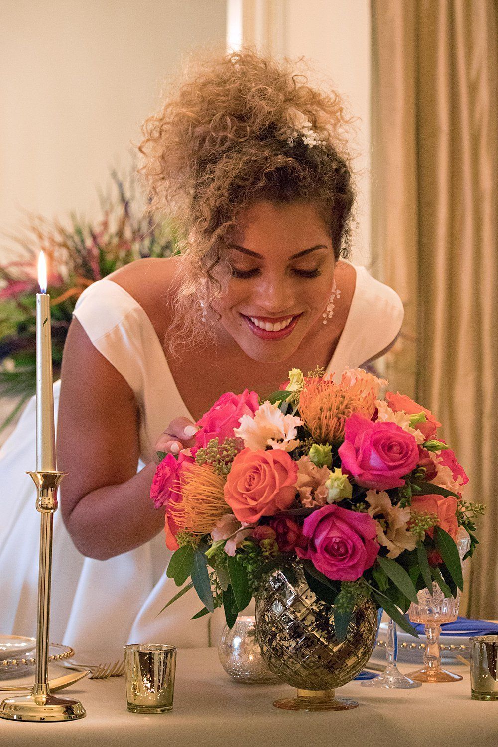 Bride smiling with colourful balloon display outside wedding venue Kent Nurstead Court