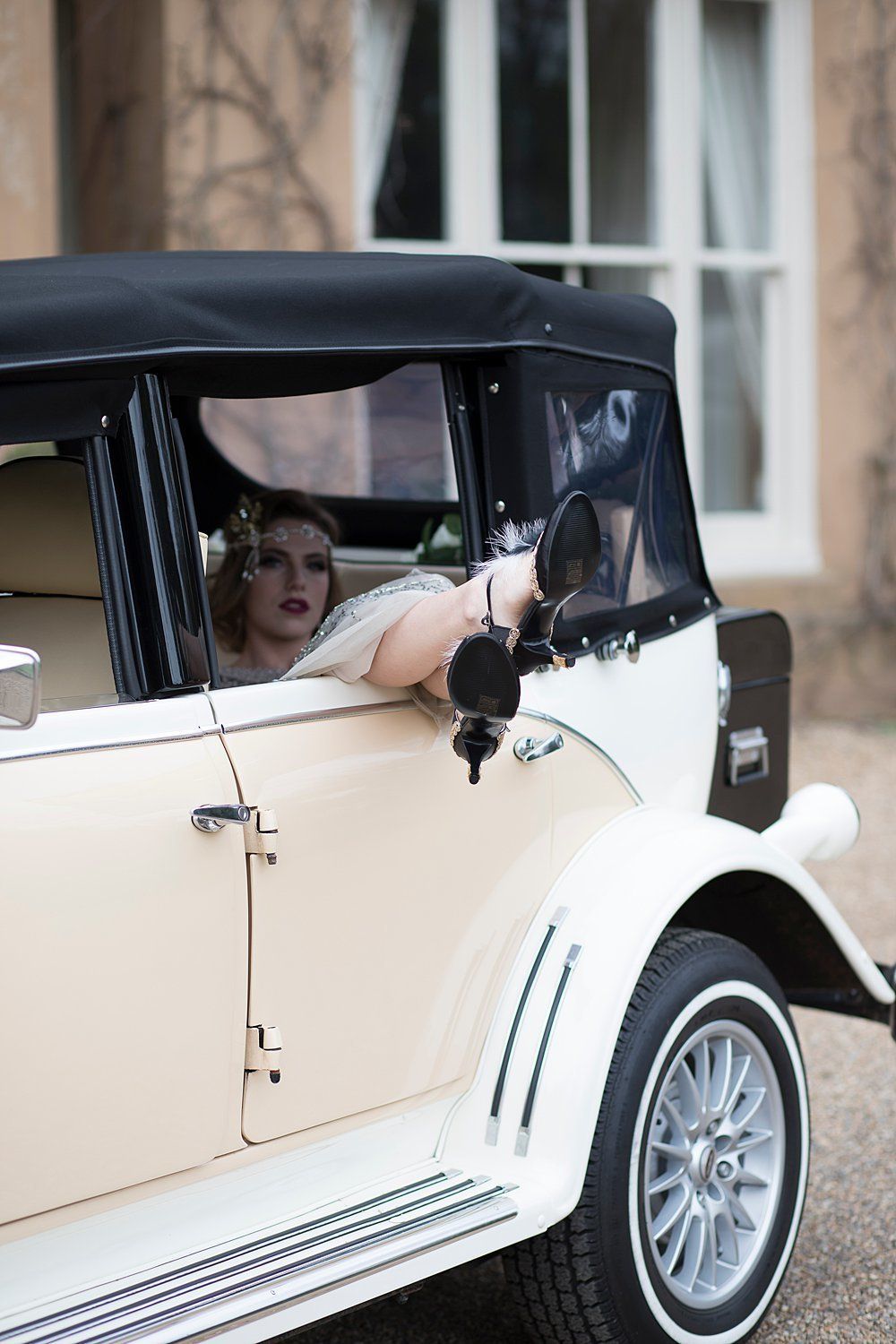 Bride with feet up in a vintage car