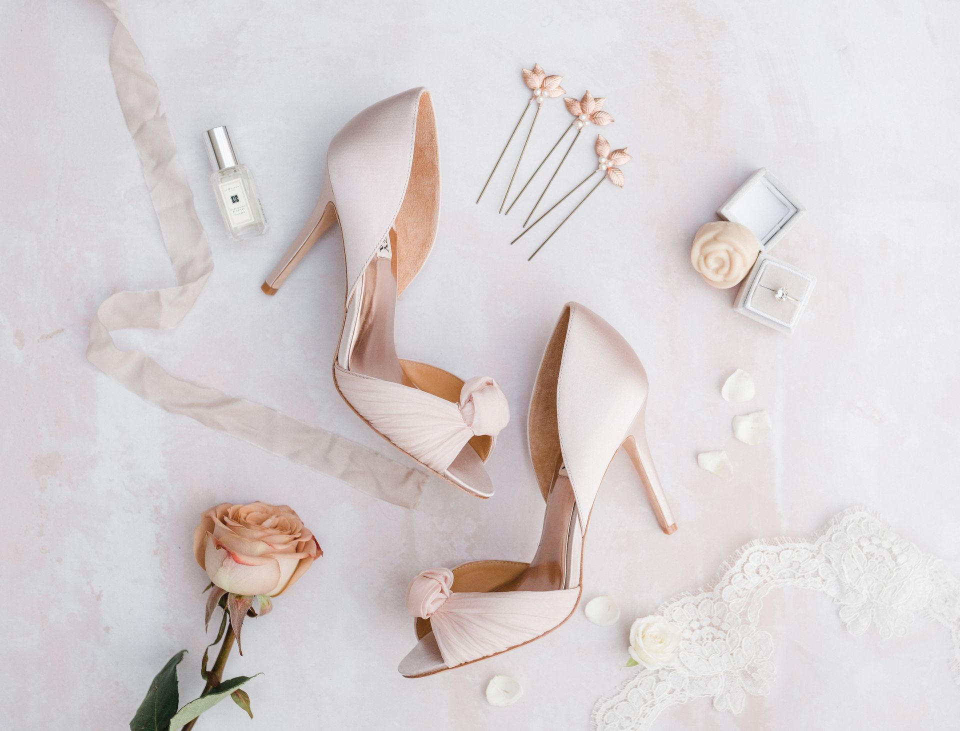 Pink wedding details including women's pink high heel shoes perfume bottle hair clips and ring