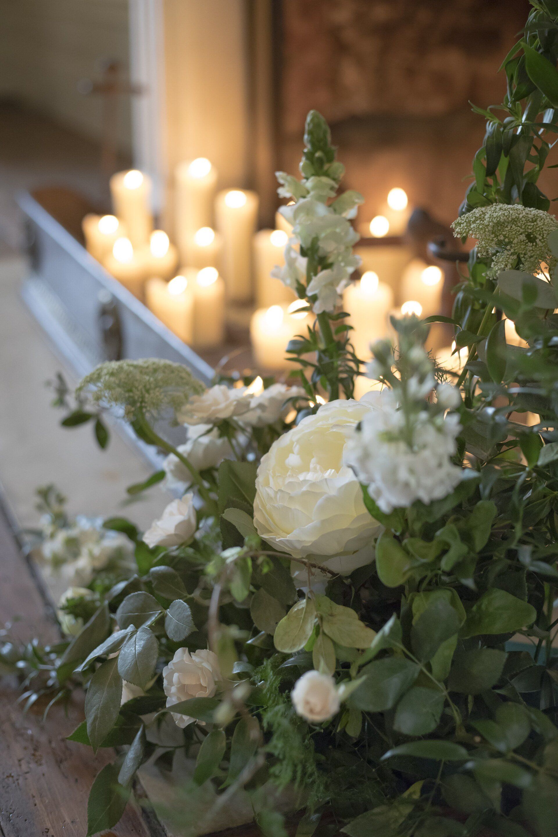 Gatsby-inspired wedding, ivory flowers decorating and a fireplace with lit pillar candles