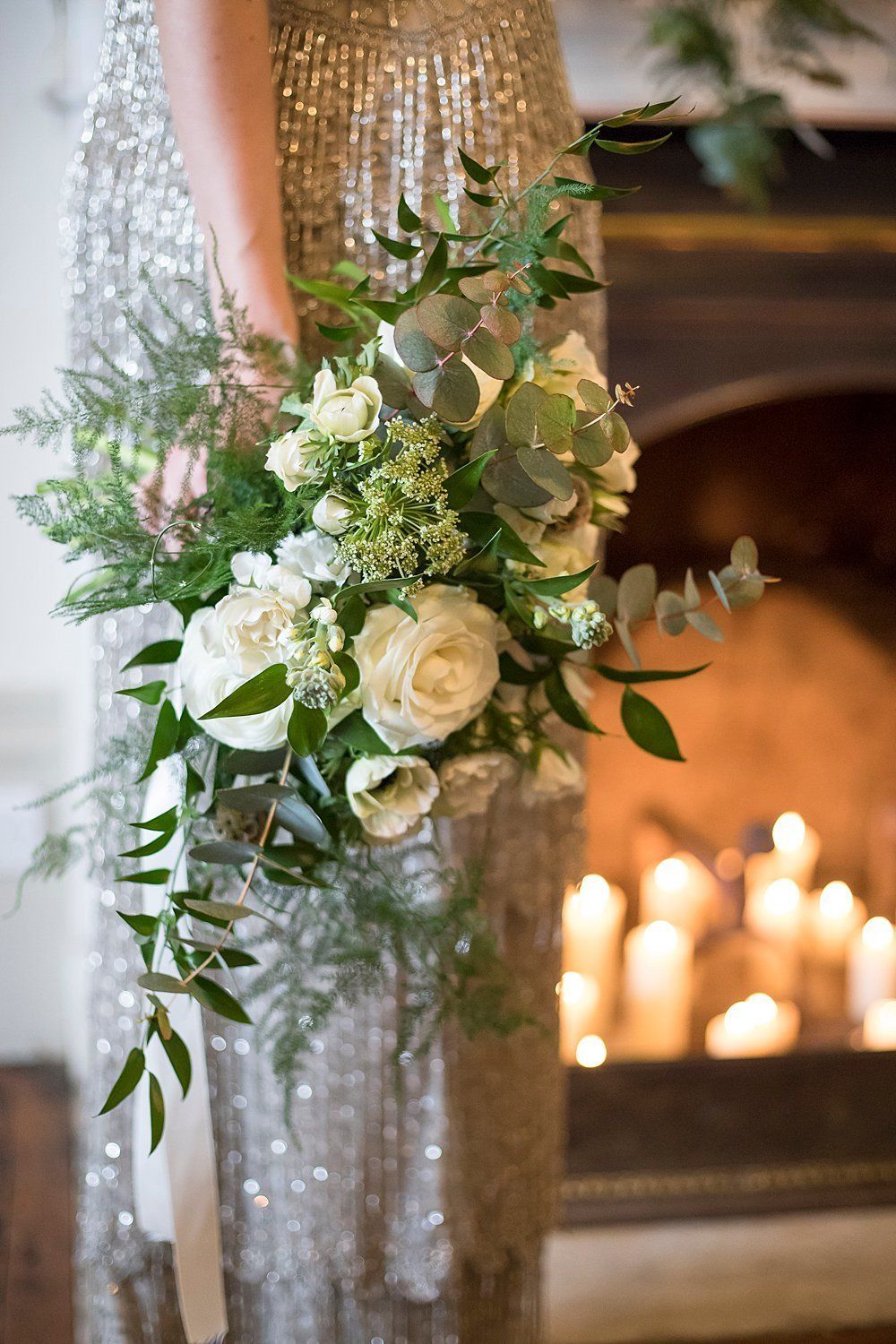 Bride holding white roses and eucalyptus bouquet