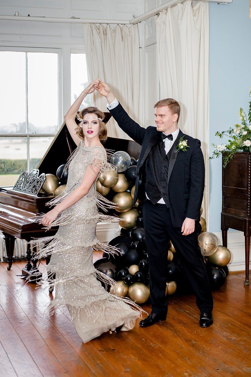 Gatsby inspired wedding couple with the groom twirling the bride