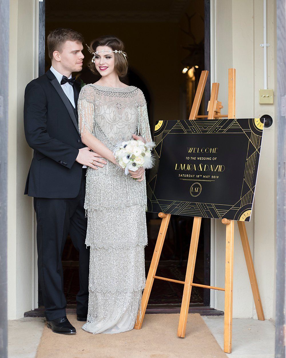 Bride and Groom standing outside Nurstead Court with wedding table plan