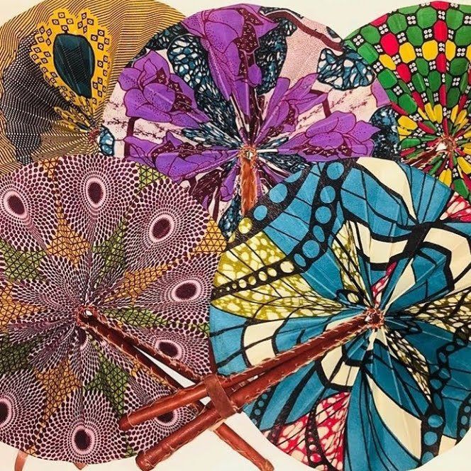 Colourful African hand fans opened on display in purple green and blue