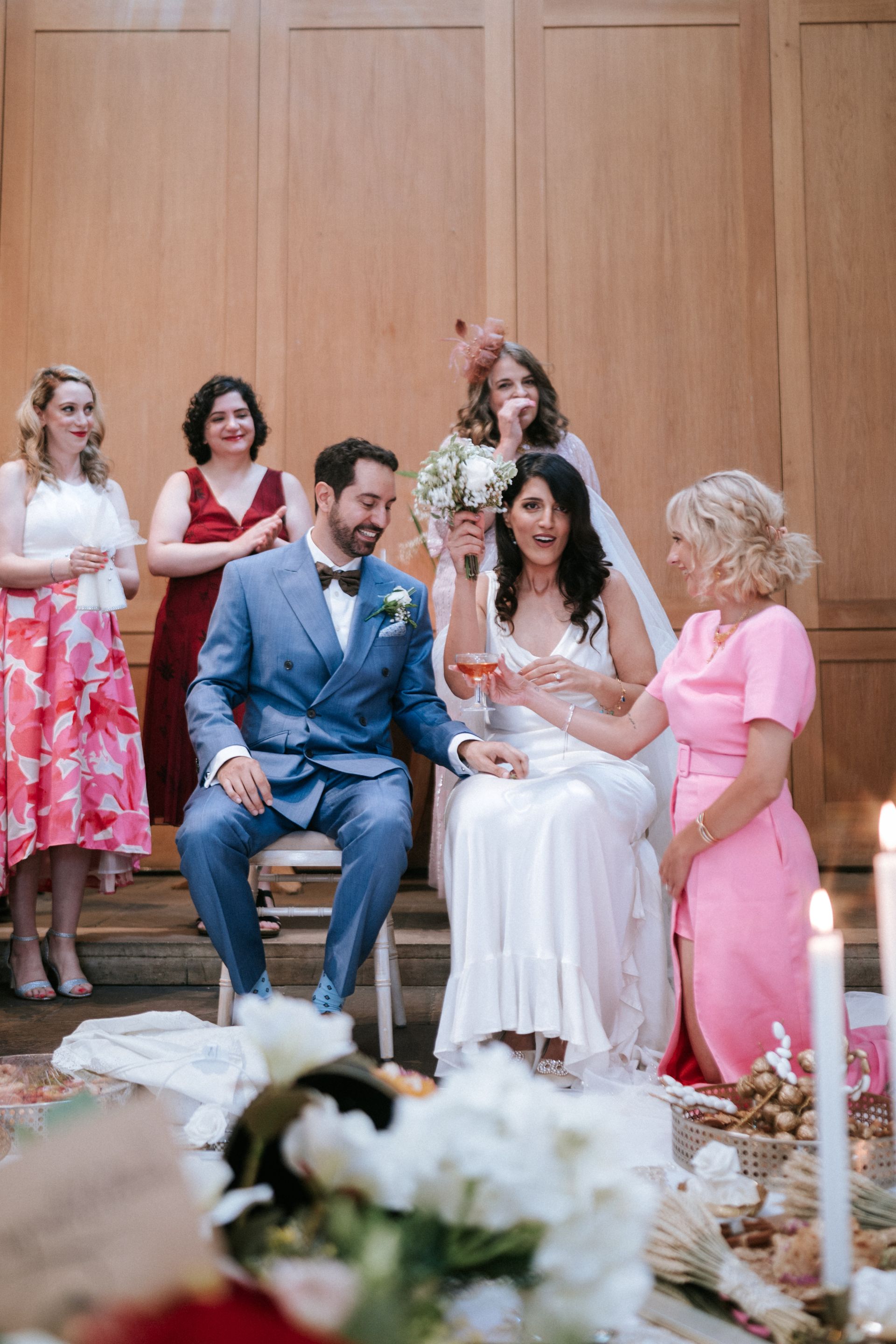 Persian wedding ceremony with bride and groom seated at sofeh aghd anbd being served wine