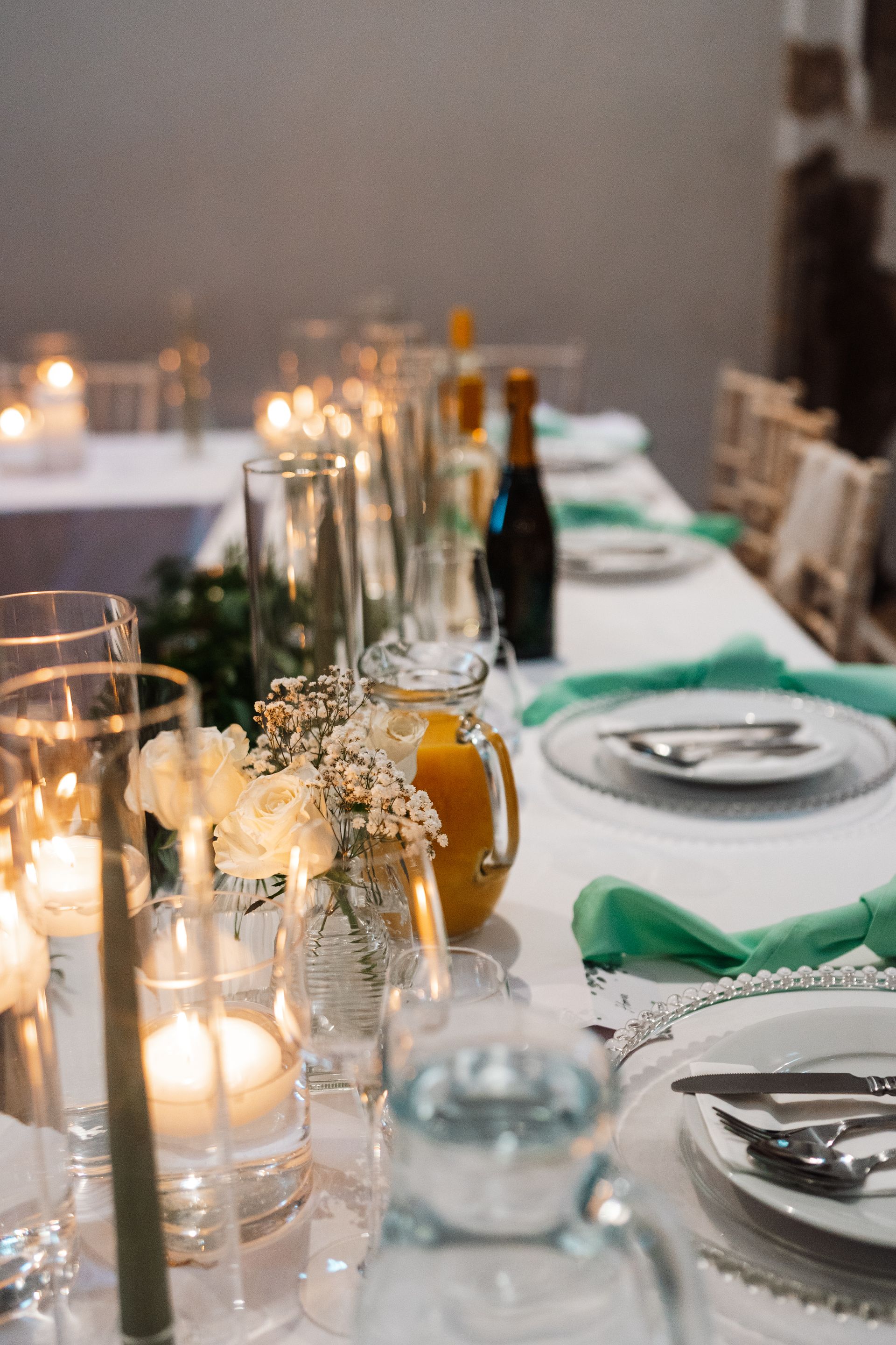 wedding reception table set up with mint green napkins and candles