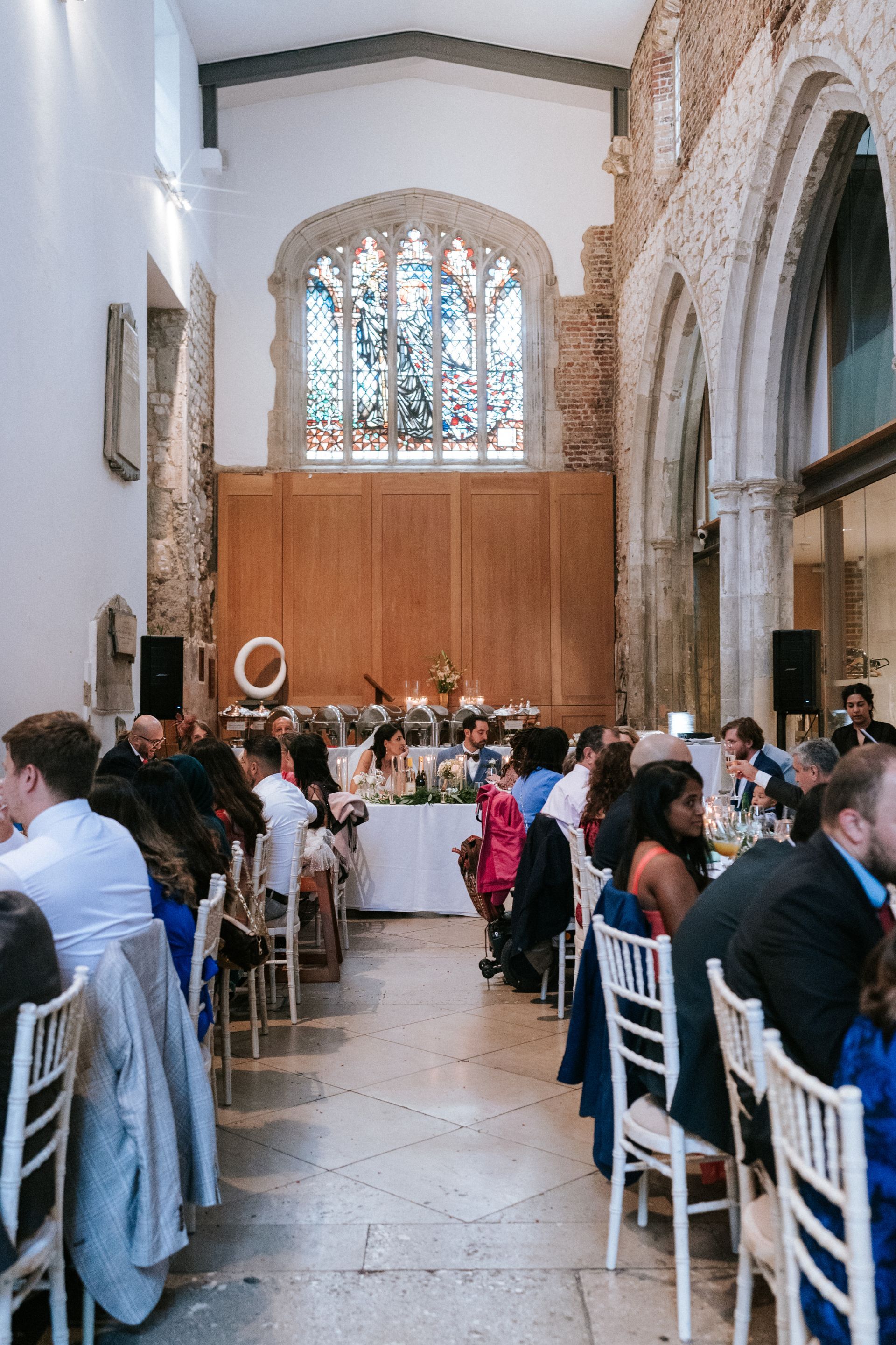 Wedding reception set up in U shape with guests seated and eating