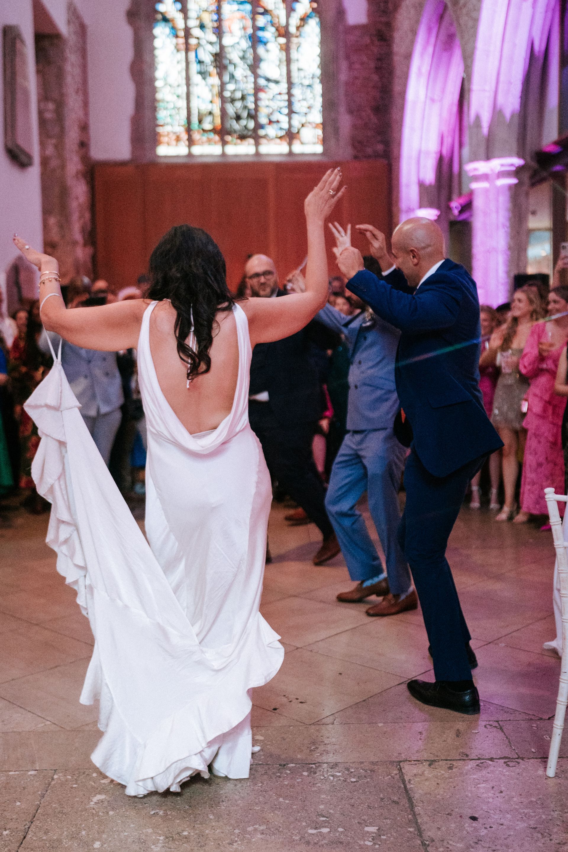 Persian dancing with bride in white dress and two men in dark suits