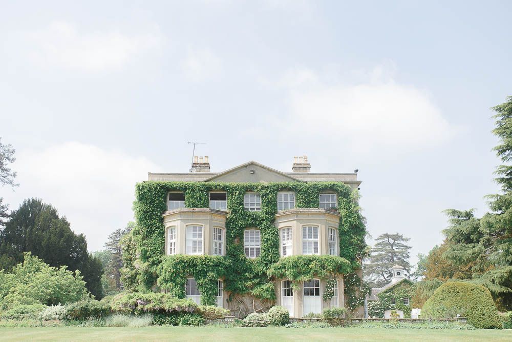 Image of the outside of Northbrook Park Manor House covered in green Wisteria