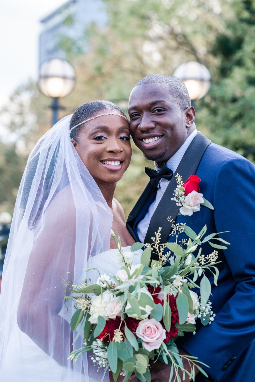 black bride with bouquet and groom smiling into camera