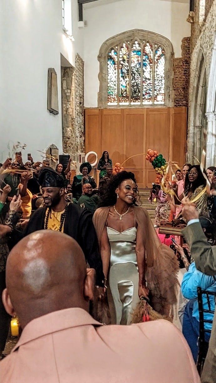 Black bride and groom wedding ceremony smiling and walking up the aisle laughing