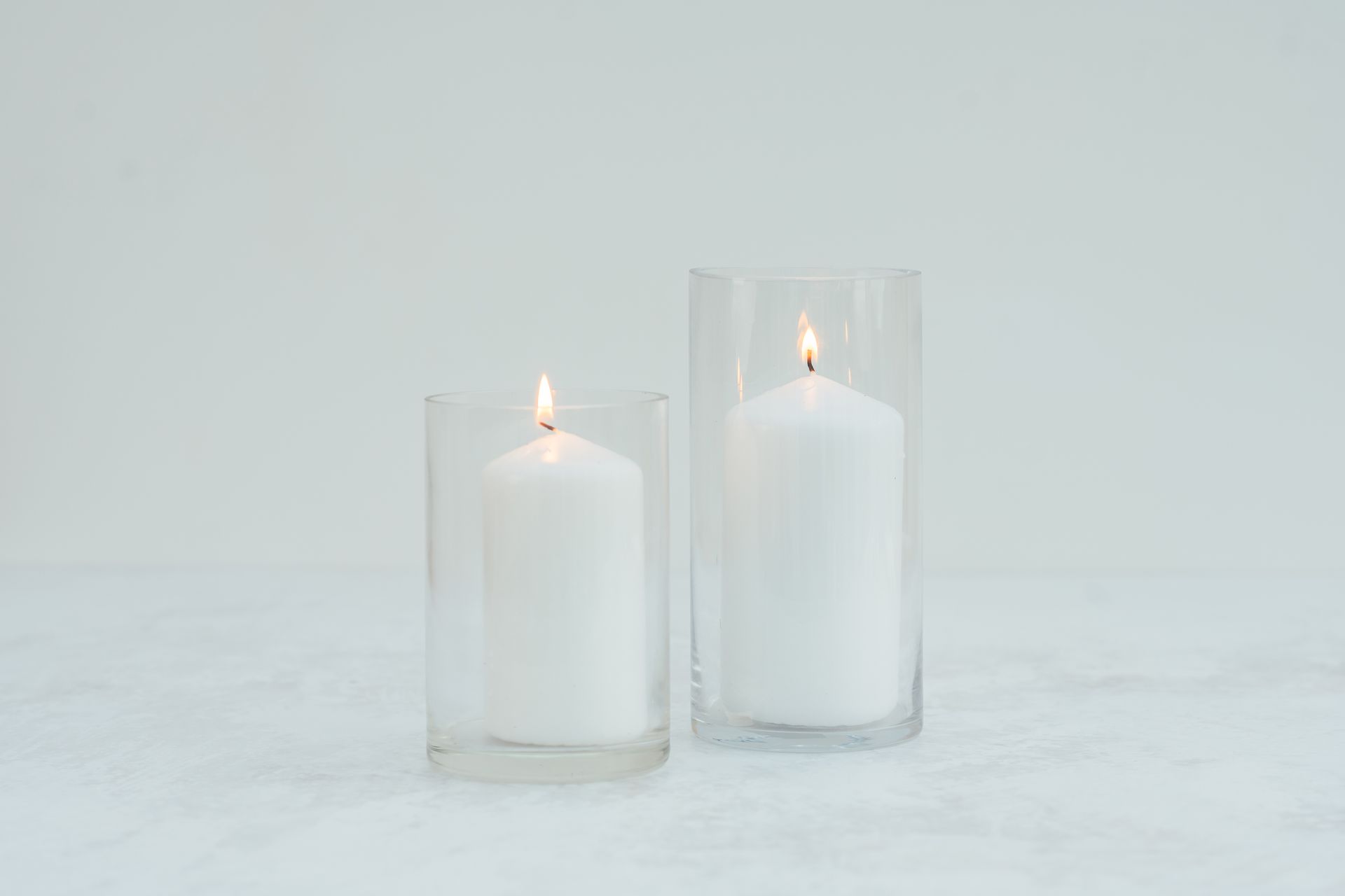 2 glass cylinder vases with white candles