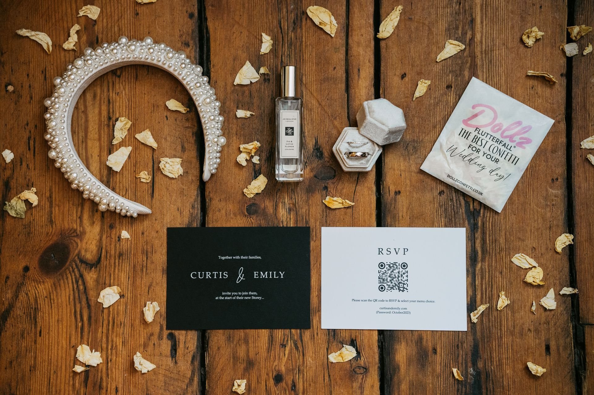 Flat lay of black and white wedding stationery on a wooden floor