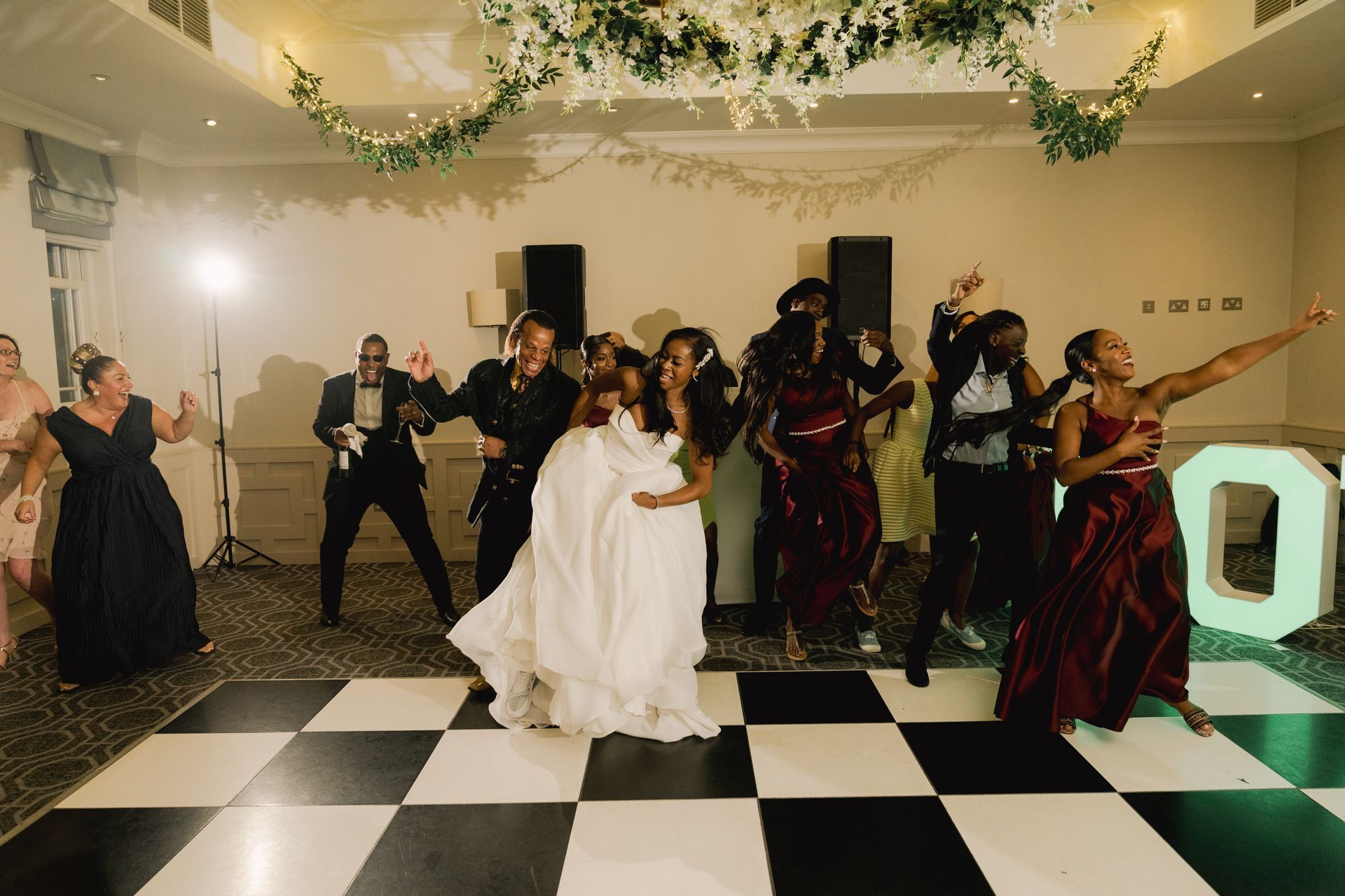 Black bride and guests dancing eneregitically