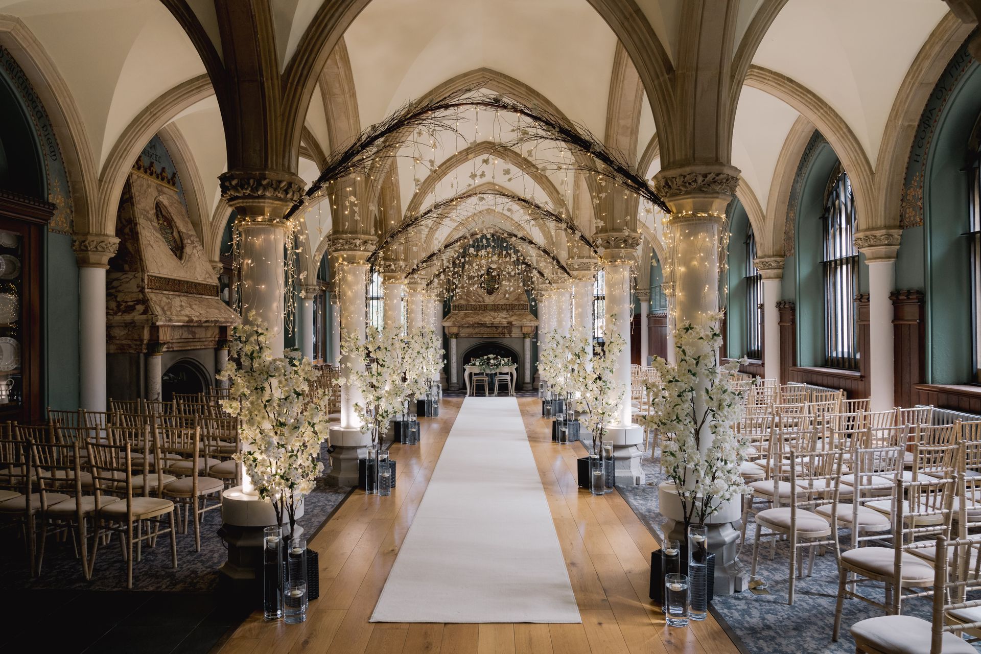 Wotton House old library ceremony decor with white blossom trees and candles