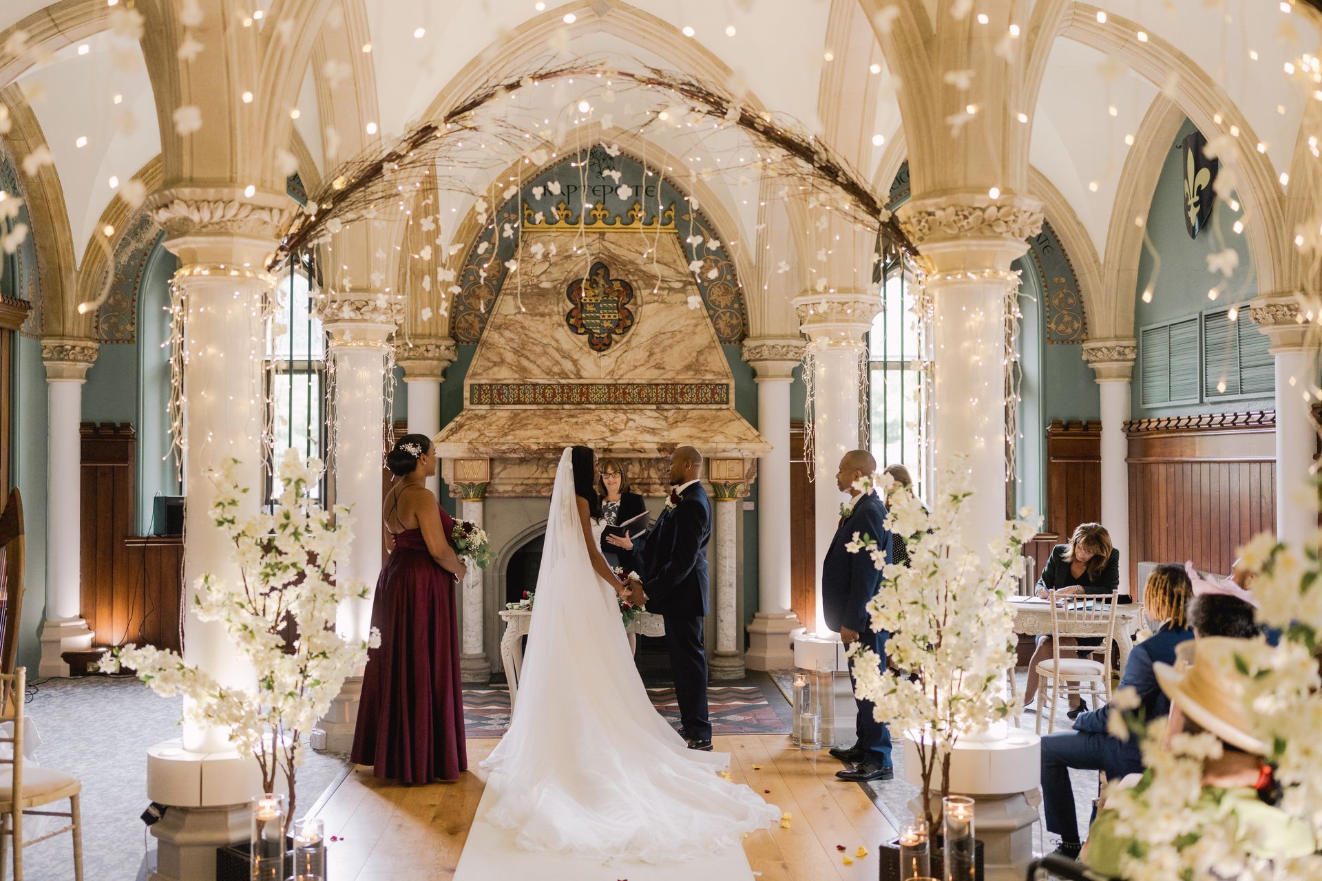 Black Bride and groom standing in front of registrar with bridesmaid and bestman standing either side