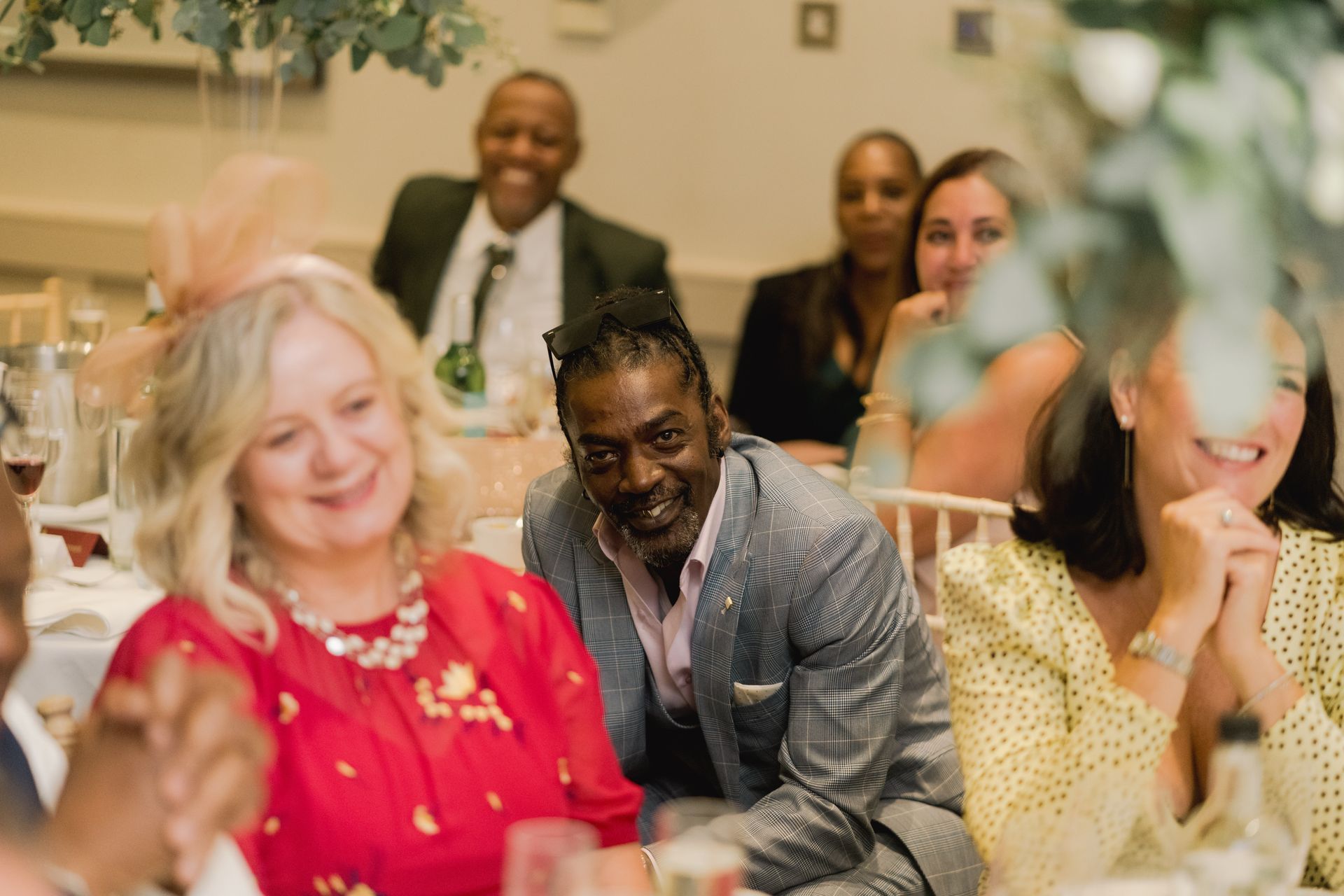 Wedding guests laughing whilst seated at wedding reception table
