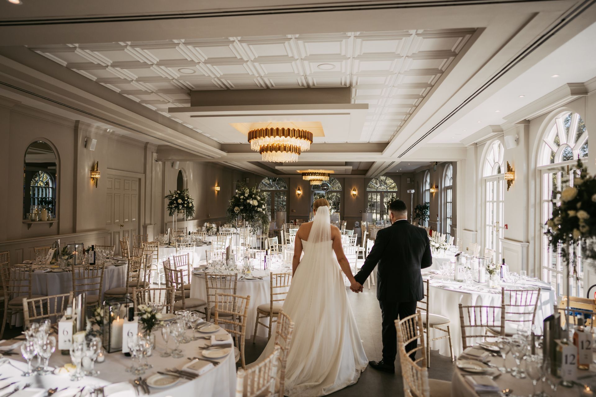 Bride and groom holding hands as they view their wedding reception at The Orangery Maidstone.
