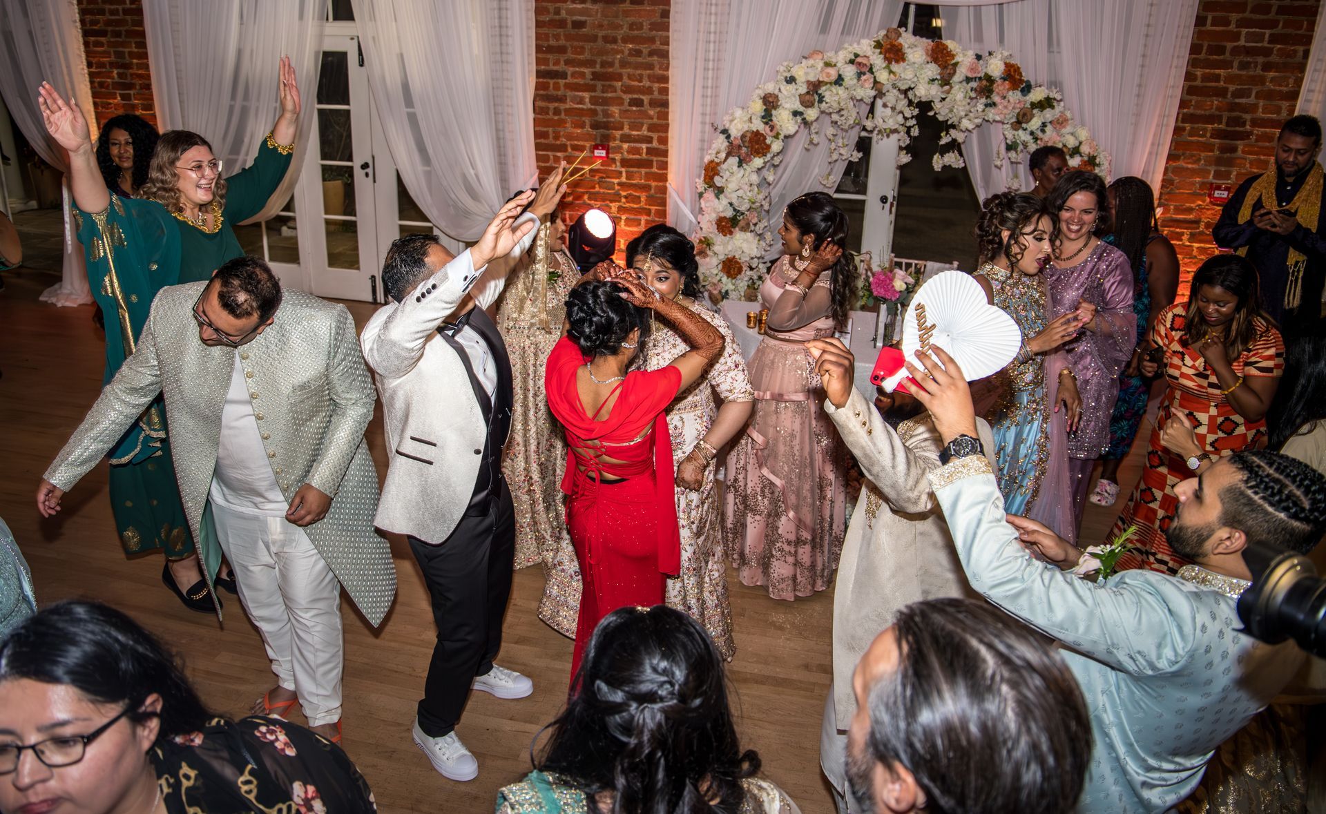 Guests dancing at a wedding with hands in the air