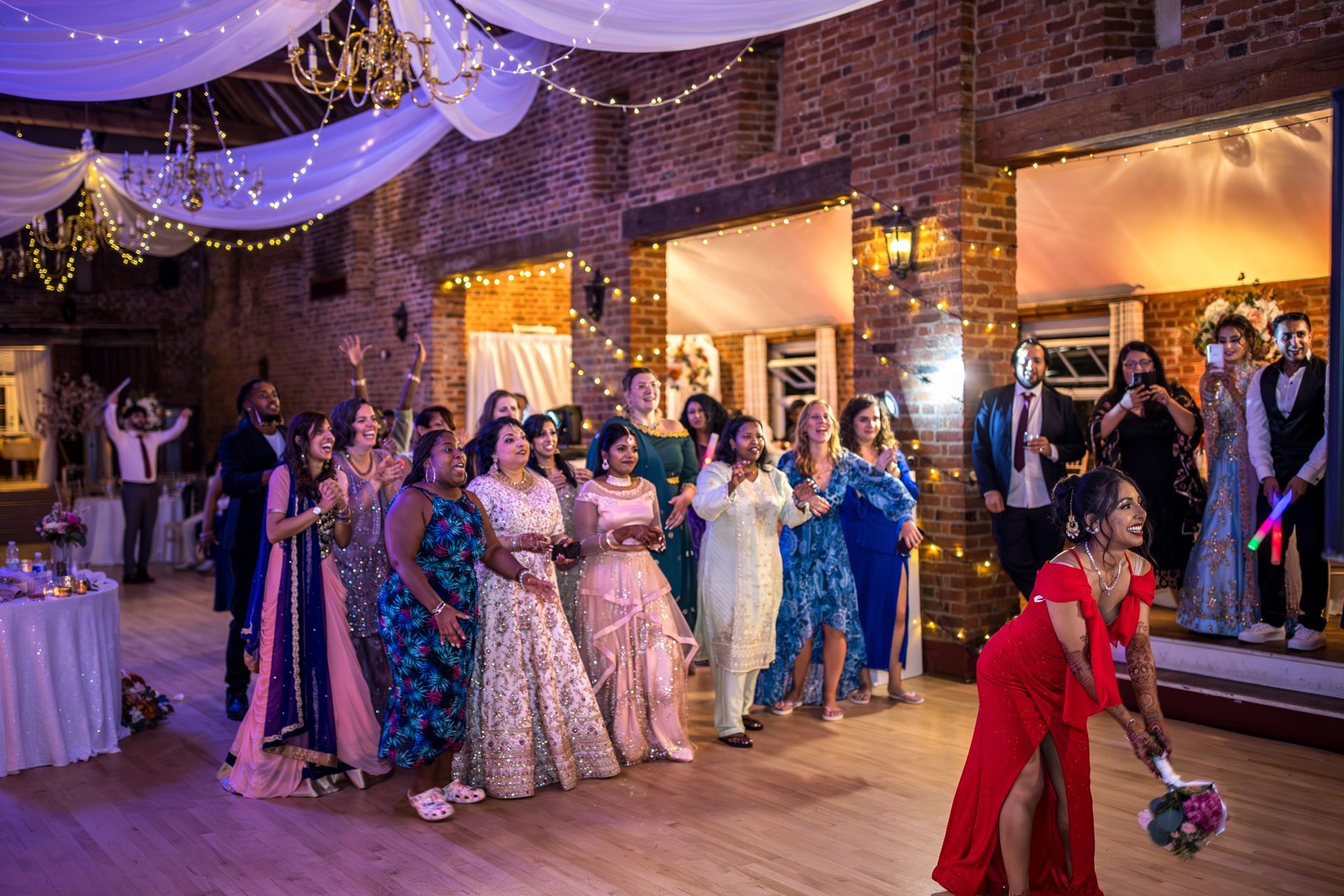 Multicultural wedding ladies standing waiting for bouquet to be tossed