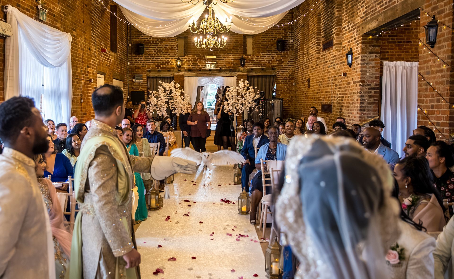 Indian groom in wedding ceremony holding a cream owl ring bearer
