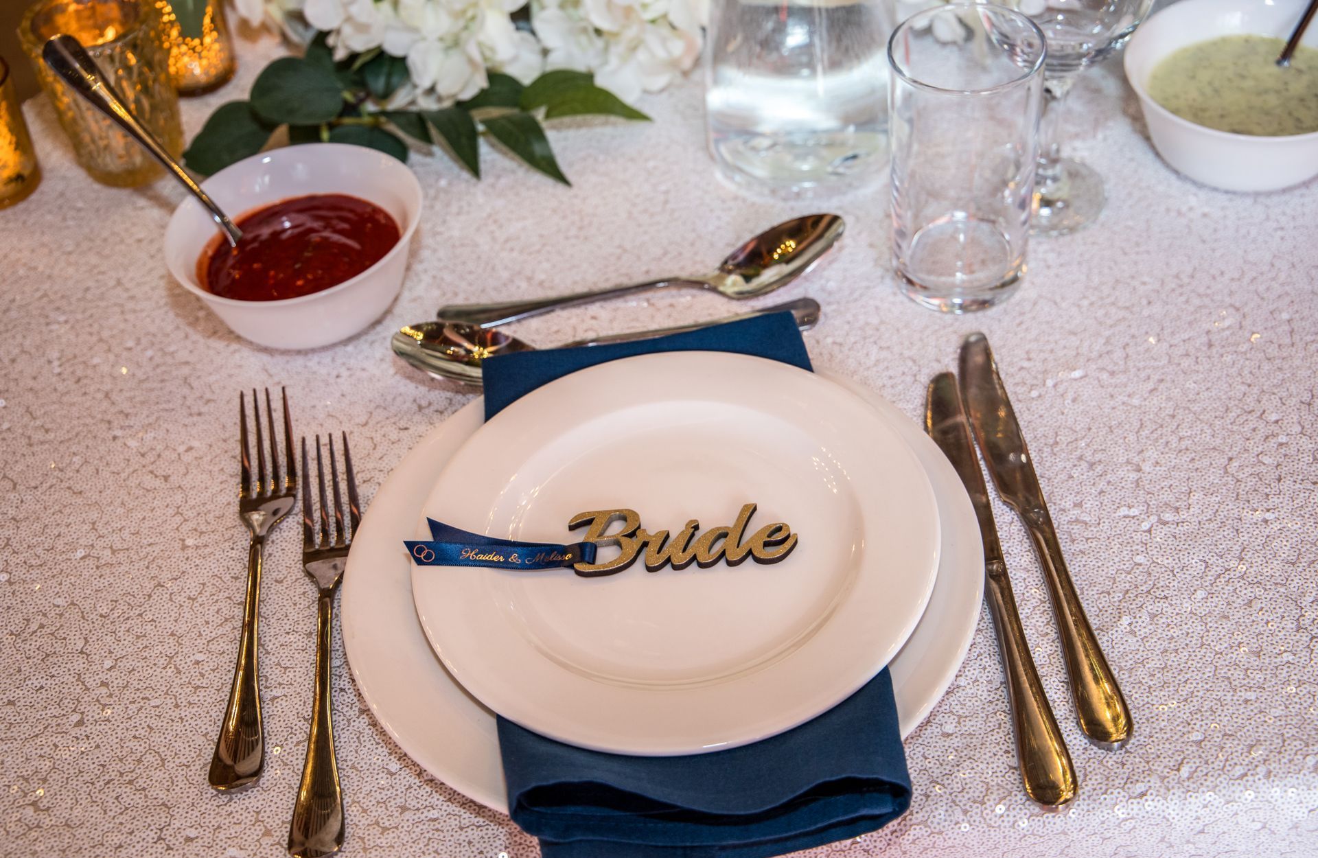 Bride in wooden keyring resting on a white dinner plate with blue napkin underneath