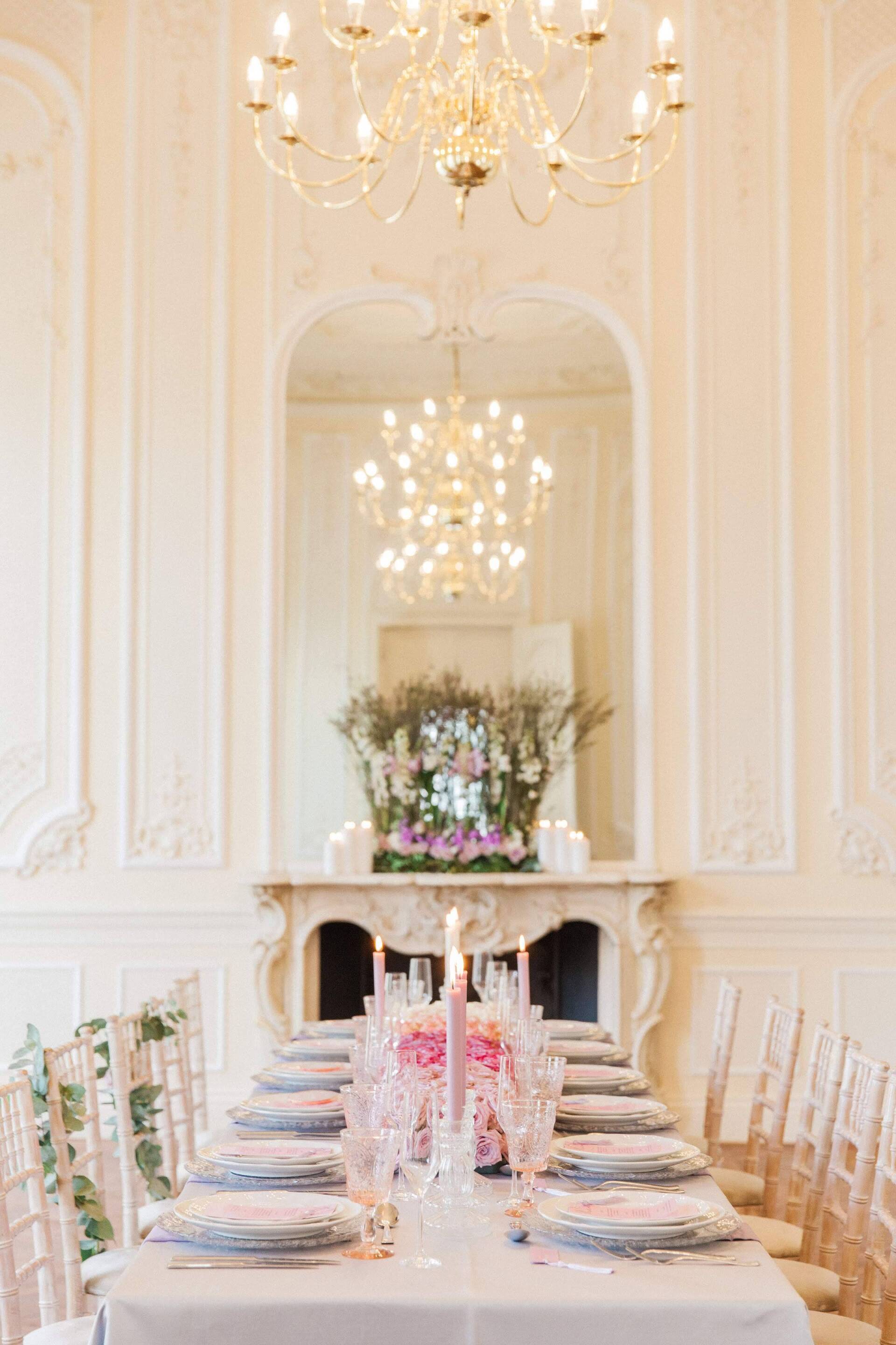 Wedding table set up with pink purple roses, cream chairs in a cream room with georgian walls