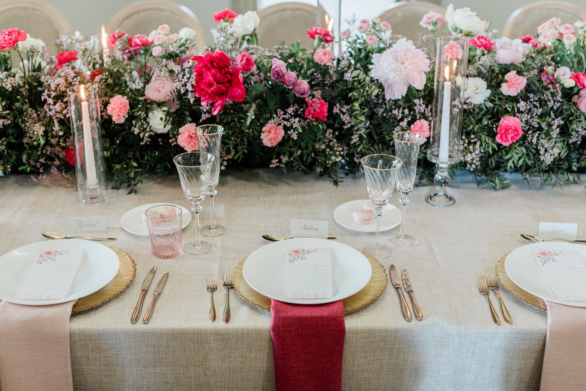 Wedding table set up by Pearline Events at Chiswick House Terrace with pink and red rose flower runner cream chairs red napkins and candles